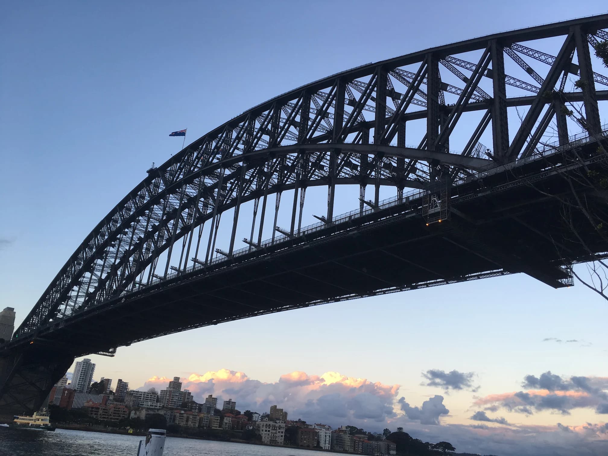 Sydney Harbour Bridge at dawn, first light on the water and the city beyond