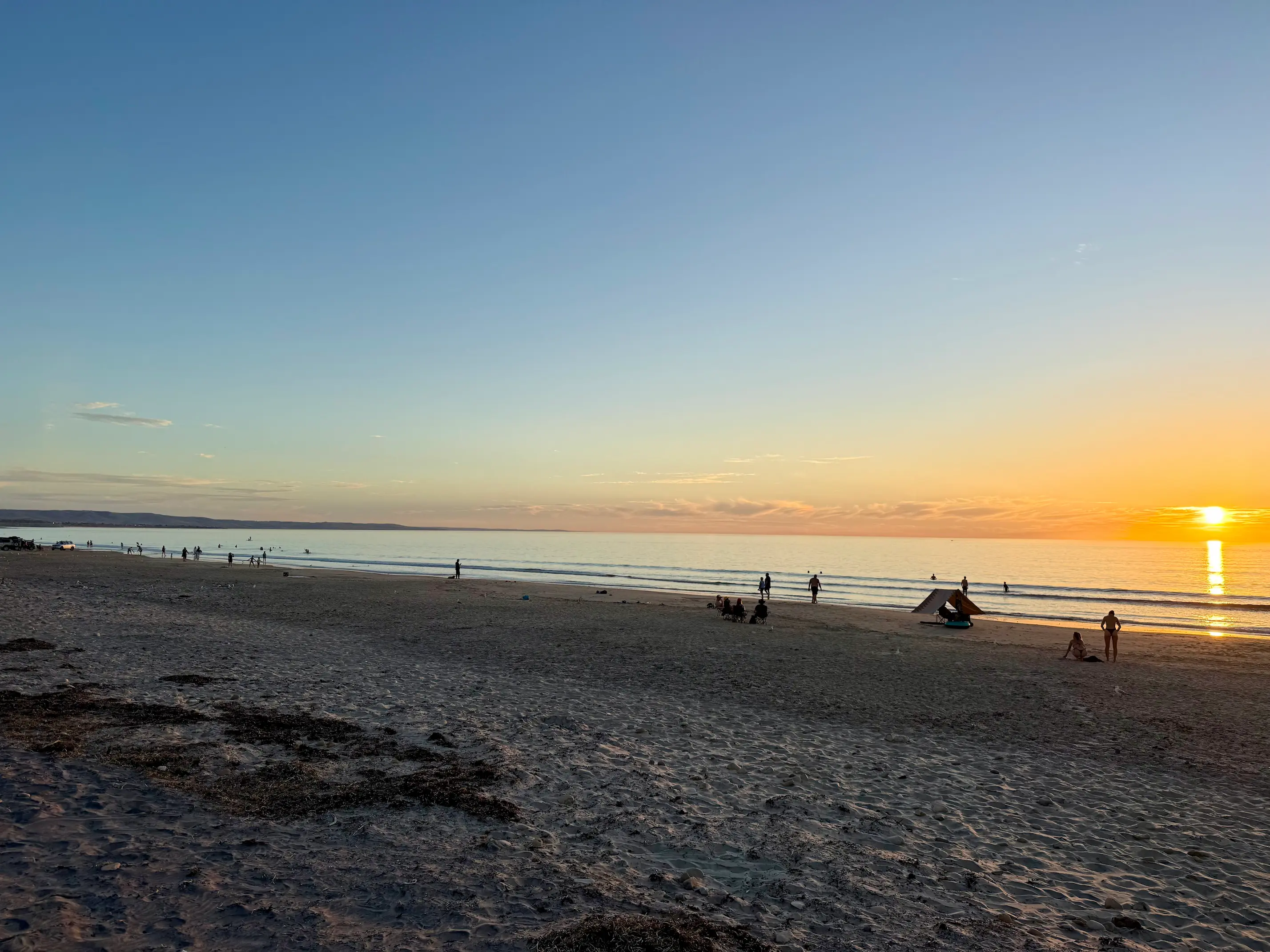 People walking down to the water at sunset on an Australian beach