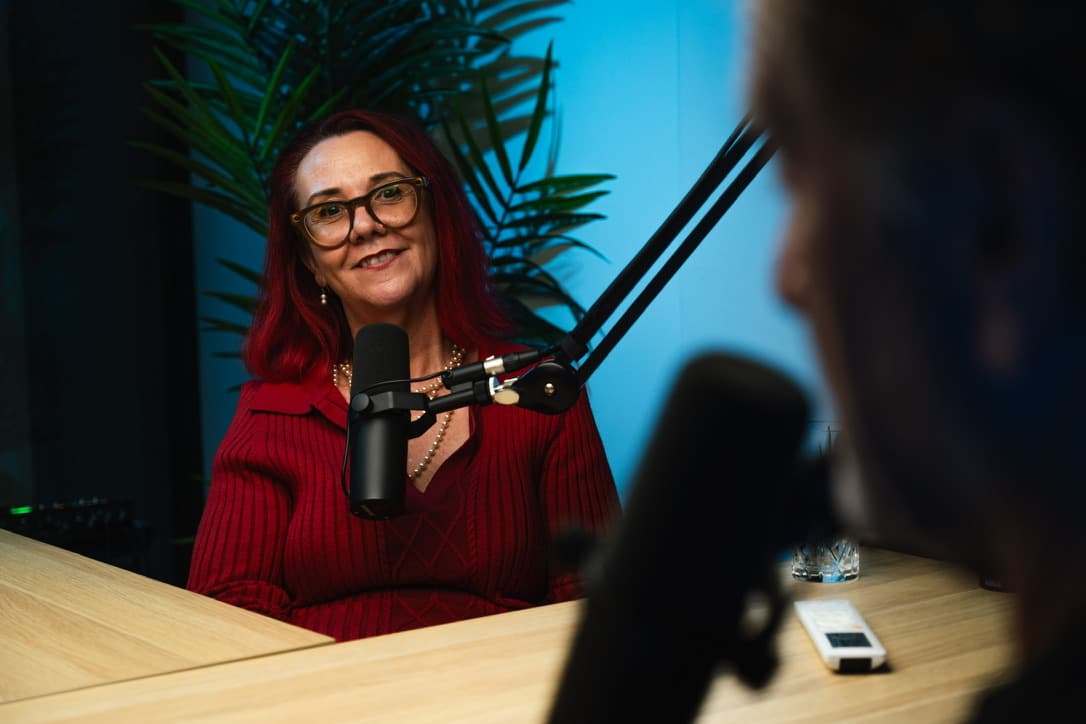 Tracy Sheen behind the microphone recording The Mentor podcast with Mark Bouris