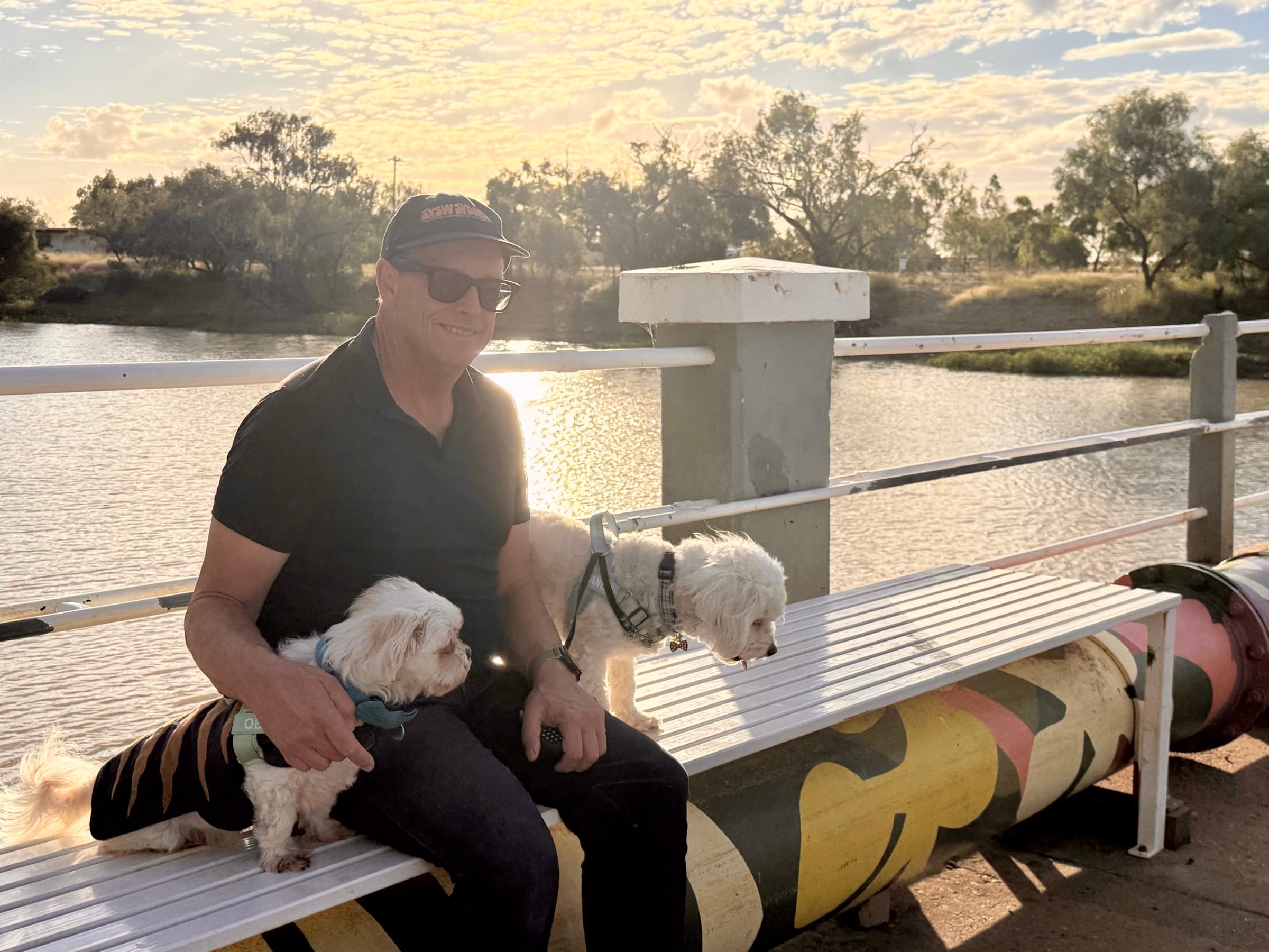 Pete watching the sunset by the water at Longreach with Obi and Lando.